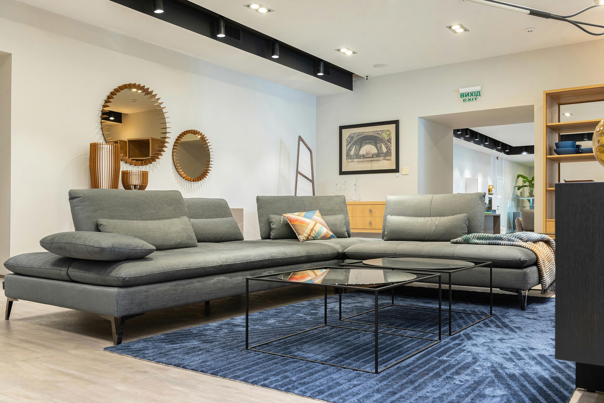Gray sectional sofa with black coffee table and blue rug