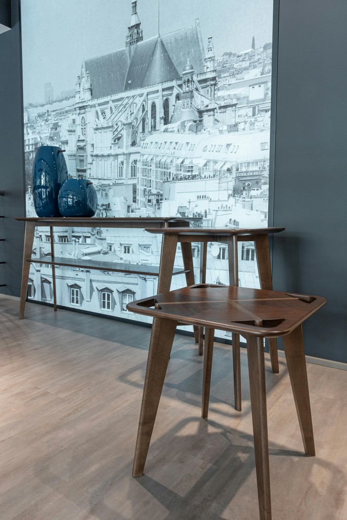 Wood tables with blue vases against a mural wall